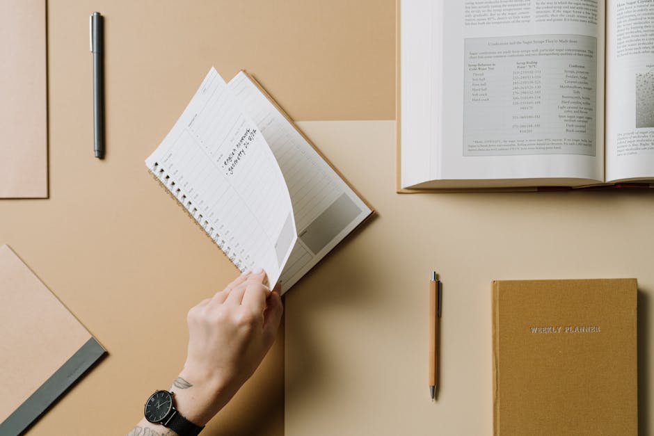 A person sitting at a desk, thoughtfully writing in a journal.